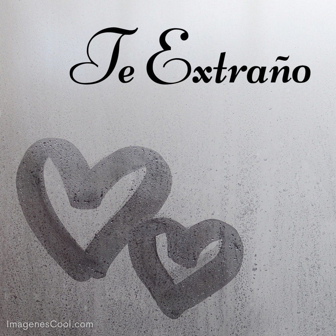 Dos corazones dibujados en un vidrio empañado con la frase 'Te Extraño' arriba